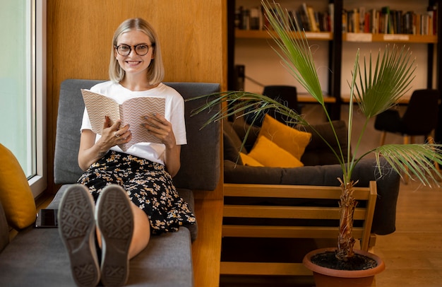 Kostenloses Foto junger student, der ein buch in der bibliothek liest