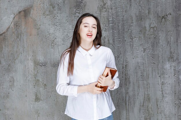 Junger Student oder Lehrer im weißen Hemd, das Buch hält. Foto in hoher Qualität