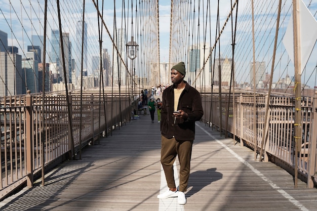Junger stylischer Mann, der alleine eine Stadtbrücke erkundet