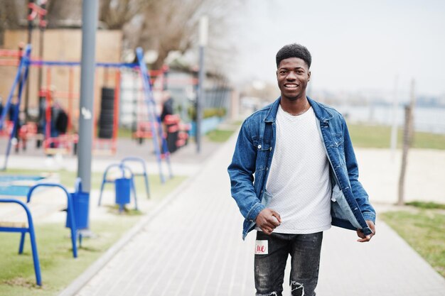 Junger tausendjähriger afrikanischer Junge in der Stadt Fröhlicher schwarzer Mann in Jeansjacke Konzept der Generation Z