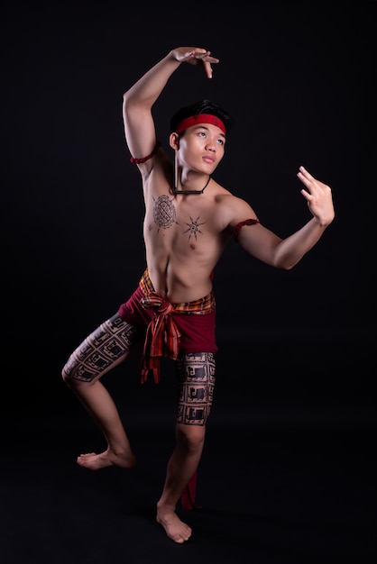 junger Thailand-Mann, der einen traditionellen Tanz tut