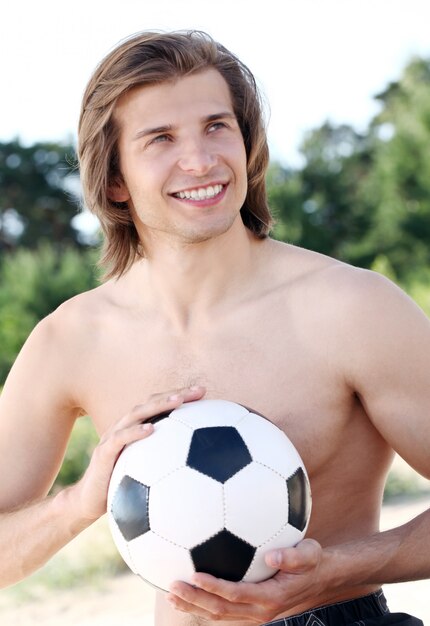 Junger und hübscher Kerl mit Fußball