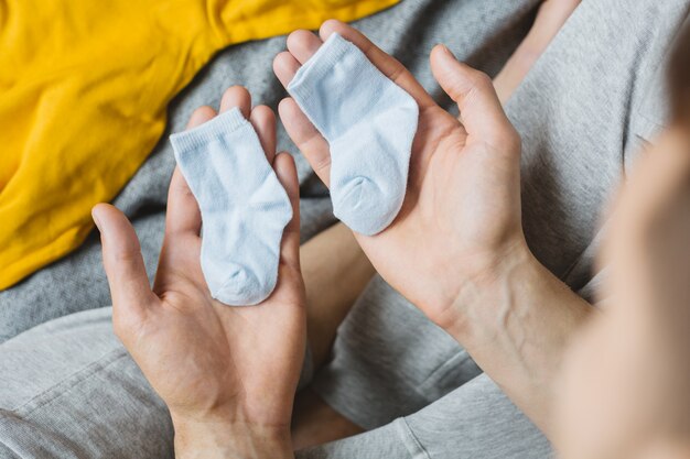 Junger Vater, der Kleidung für Baby vorbereitet