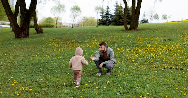 Kostenloses Foto junger vater mit seinem baby im freien