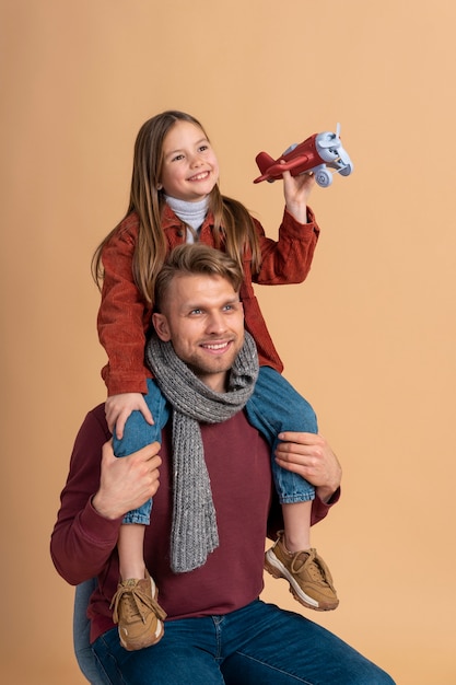 Junger Vater und Tochter spielen zusammen, bevor sie mit dem Spielzeugflugzeug reisen