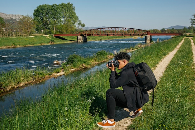 Junger Wanderer, der Foto von idyllischem Fluss macht