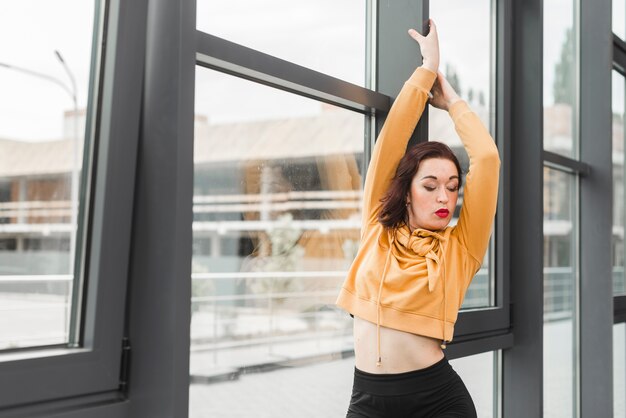 Junger weiblicher Hip-Hop-Tänzer, der herein vom Fenster aufwirft
