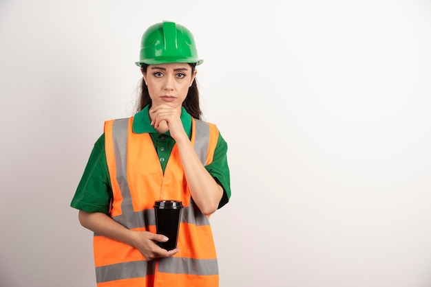 Junger weiblicher Konstrukteur, der schwarze Tasse hält. Foto in hoher Qualität