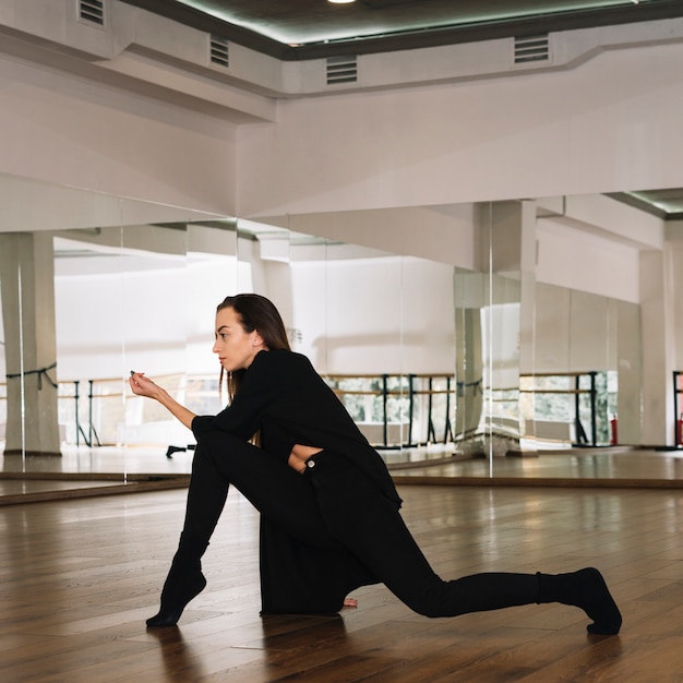 Junger weiblicher Tänzer, der im Tanzstudio übt