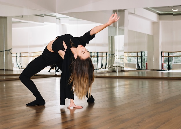 Junger weiblicher Tänzer, der im Tanzstudio übt