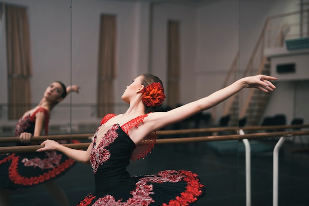 Junger weiblicher Tänzer des klassischen Balletts übend im Tanzstudio