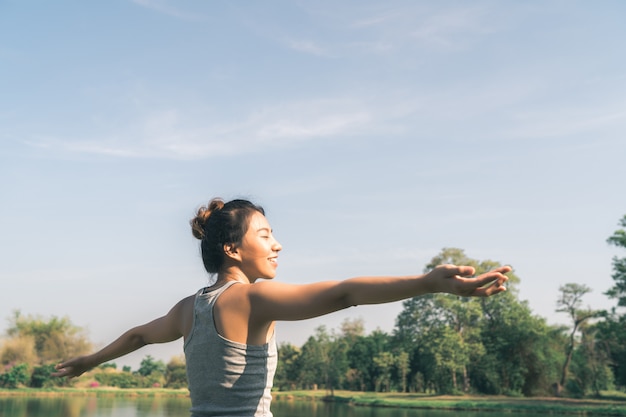 Junges asiatisches Frauenyoga draußen halten ruhig und meditieren beim Üben von Yoga