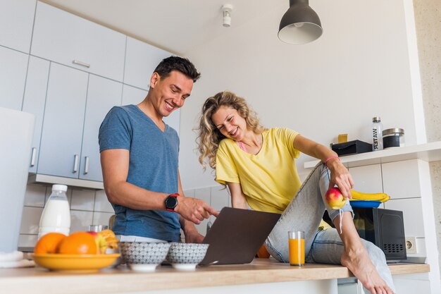 Junges attraktives Paar von Mann und Frau, die Frühstück am Morgen in der Küche kochen, bleiben zusammen zu Hause allein