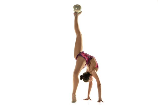 Junges flexibles mädchen lokalisiert auf weißem hintergrund. weibliches modell im teenageralter als rhythmische gymnastikkünstlerin, die mit geräten übt.