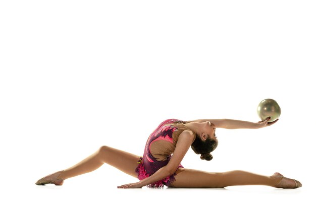 Junges flexibles Mädchen lokalisiert auf weißem Studiohintergrund. Weibliches Modell im Teenageralter als rhythmische Gymnastikkünstlerin, die mit Geräten übt. Übungen für Flexibilität, Gleichgewicht. Anmut in Bewegung, Sport.