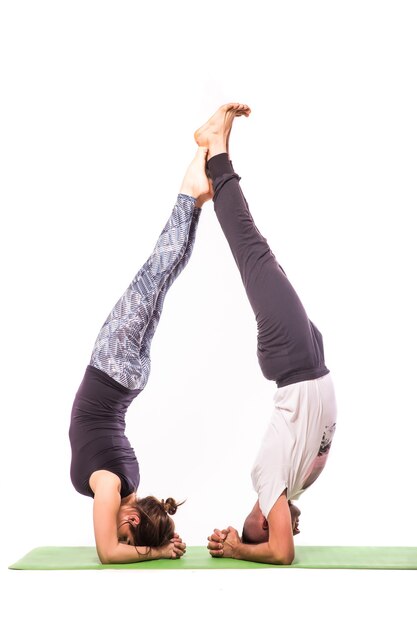 Junges gesundes Paar in der Yoga-Position lokalisiert auf weißem Hintergrund