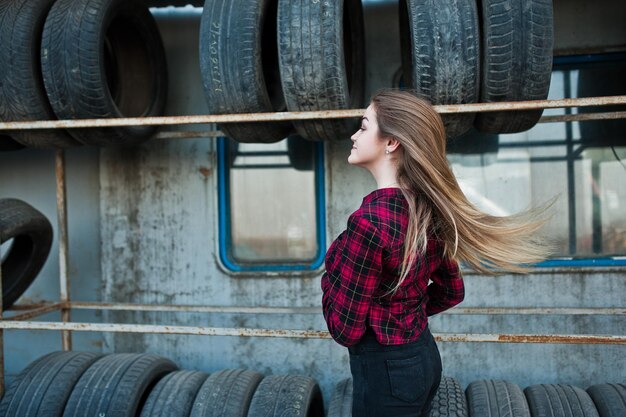 Junges Hipster-Mädchen im karierten Hemd in der Reifenmontagezone