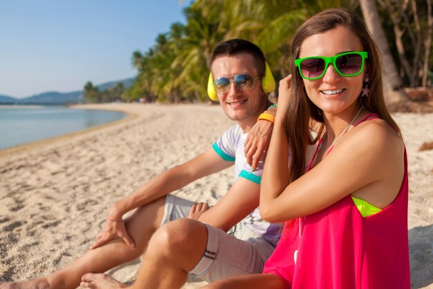 Junges Hipster-Paar verliebt, tropischer Strand, Urlaub, sommerlicher trendiger Stil, Sonnenbrille, Kopfhörer