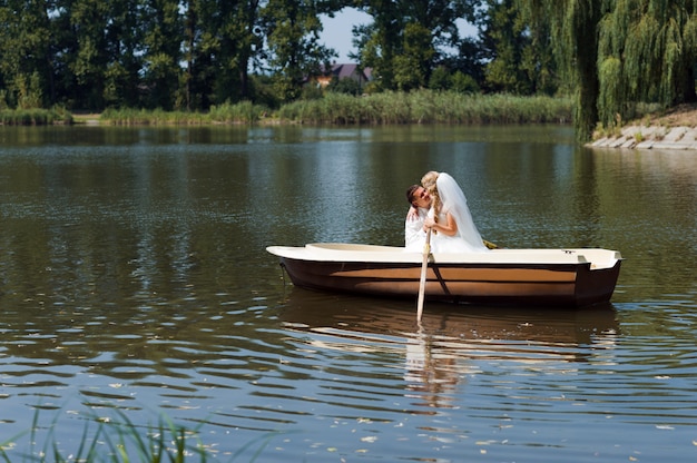 Junges Hochzeitspaar, das auf dem Boot segelt