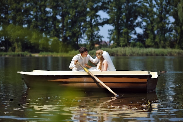 Junges Hochzeitspaar, das auf dem Boot segelt
