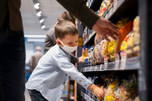 Junges Kind beim Einkaufen mit Gesichtsmaske