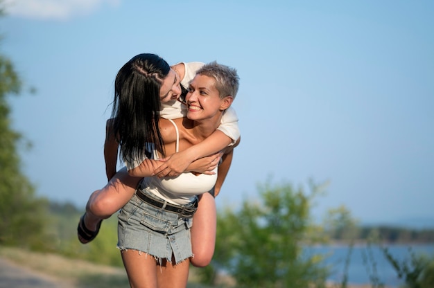 Kostenloses Foto junges lesbisches paar huckepack fahren