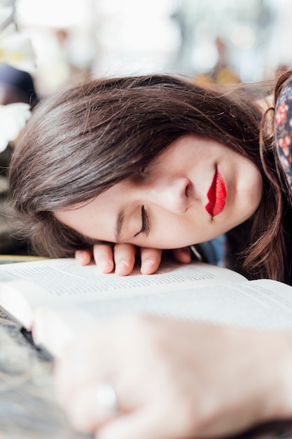 Junges Mädchen auf einem Tisch mit einem Buch