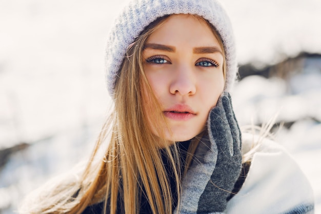 Junges Mädchen, das Decke auf einem schneebedeckten Feld trägt