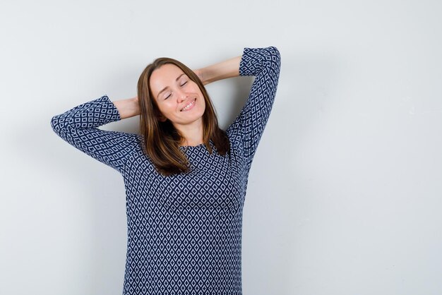 Junges Mädchen, das ihre Hände hinter dem Kopf verschränkt ruht