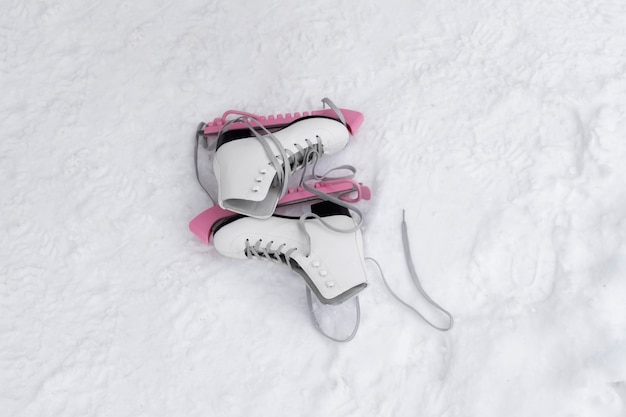 Kostenloses Foto junges mädchen, das im winter ihre schlittschuhe im freien anzieht