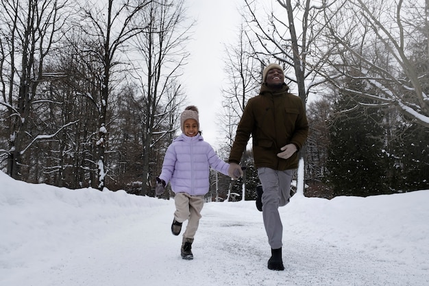 Junges Mädchen, das im Winter mit ihrem Vater spazieren geht