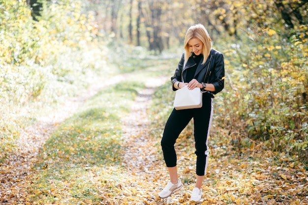 Kostenloses Foto junges mädchen, das in herbstpark geht