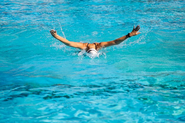 Junges Mädchen, das innerhalb des Schwimmbades aufwirft