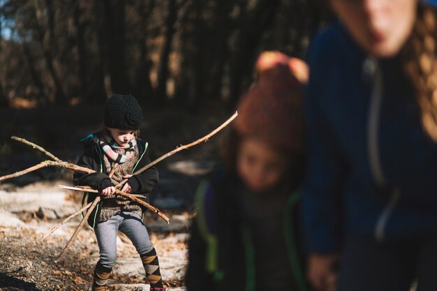 Junges Mädchen, das Niederlassungen im Wald sammelt