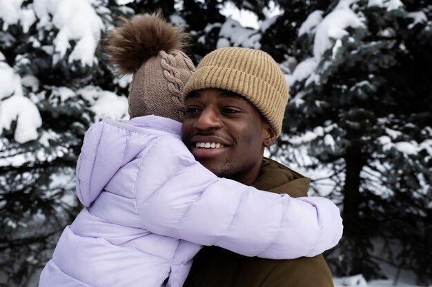 Junges Mädchen, das sich an einem verschneiten Wintertag mit ihrem Vater amüsiert