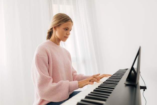 Junges Mädchen, das Tastaturinstrument zu Hause spielt