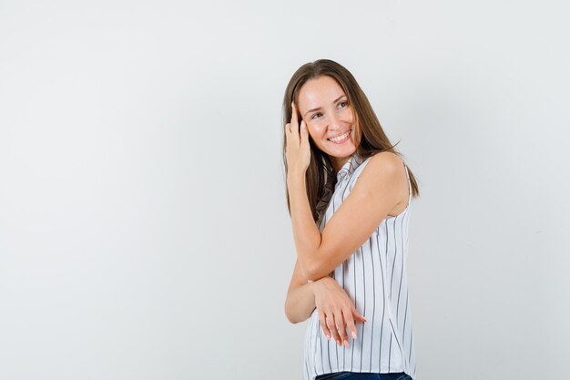 Junges Mädchen, das weg in T-Shirt, Jeans schaut und optimistisch schaut.