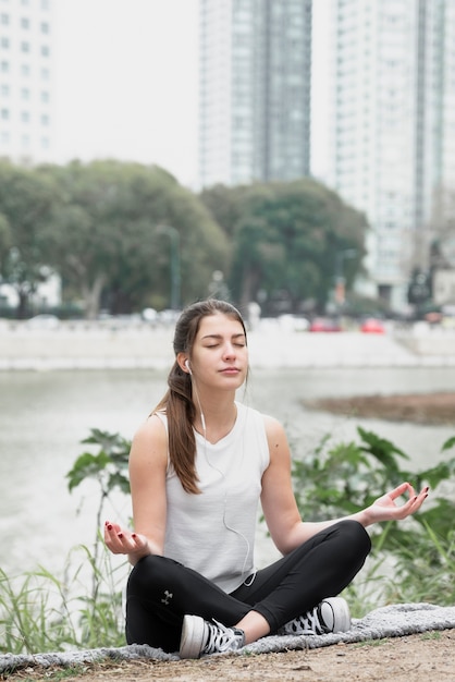 Kostenloses Foto junges mädchen der vorderansicht, das yoga tut