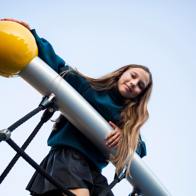 Junges Mädchen des niedrigen Winkels, das Spaß am Spielplatz hat