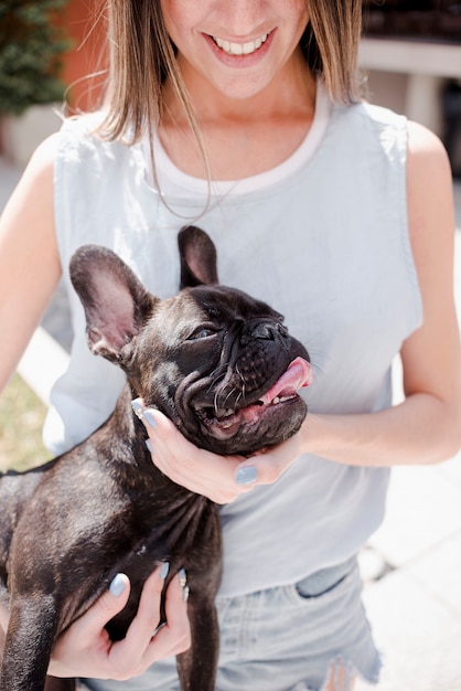 Junges Mädchen des smiley, das einen Hund anhält