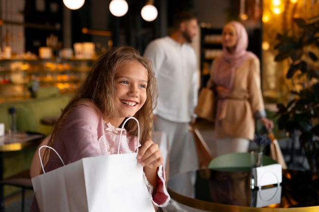 Junges Mädchen geht mit ihren Eltern auf Einkaufstour