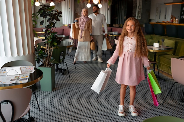 Junges Mädchen geht mit ihren Eltern auf Einkaufstour