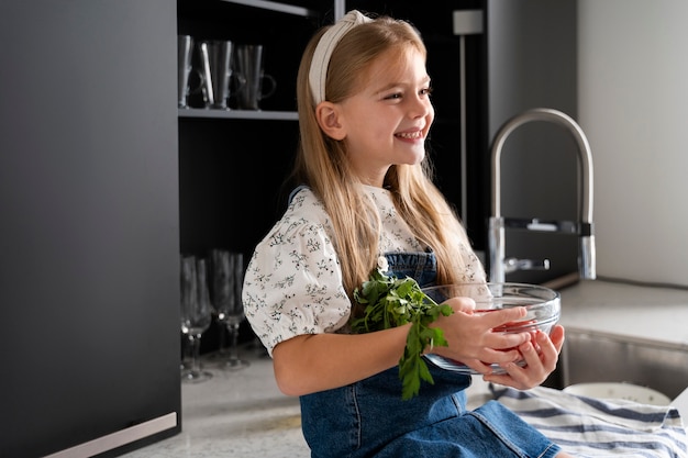 Kostenloses Foto junges mädchen hilft beim kochen