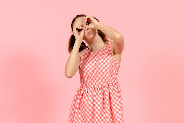 junges Mädchen im niedlichen rosa Kleid auf rosa