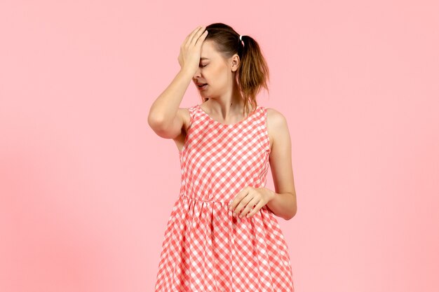 junges Mädchen im niedlichen rosa Kleid auf rosa