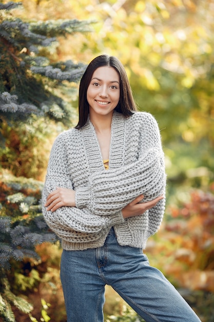 Kostenloses Foto junges mädchen in einem grauen pullover, der draußen aufwirft