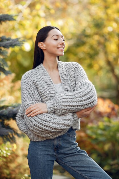 Junges Mädchen in einem grauen Pullover, der draußen aufwirft