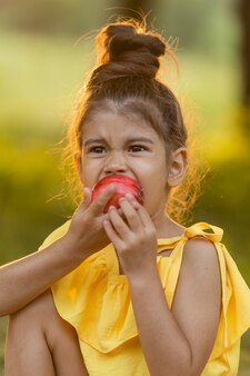 Junges mädchen isst ein gekochtes mais-gvo-freies essen kinder essen obst im freien gesunder snack für kinder Premium Fotos