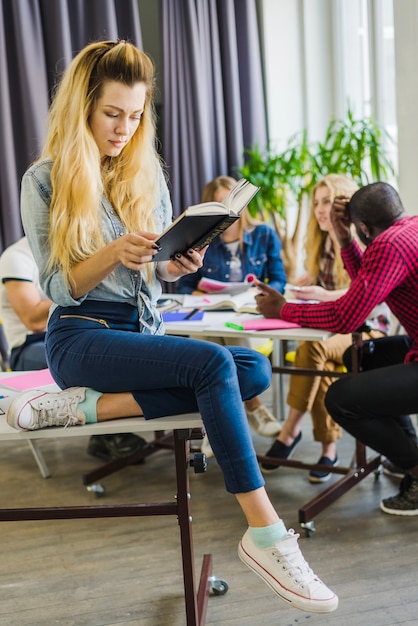 Junges Mädchen liest Buch im Klassenzimmer