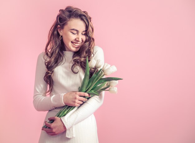 Junges Mädchen mit Tulpen auf einer farbigen Wand